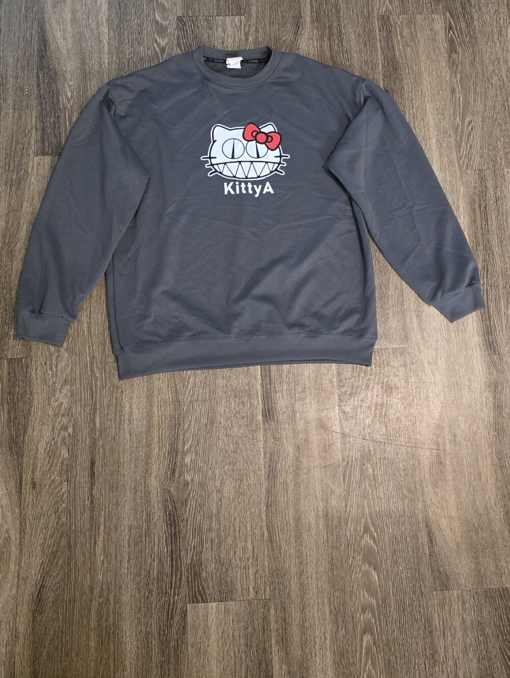 Gray round neck sweatshirt with a Hello Kitty graphic smiling "KittyA." Talla M